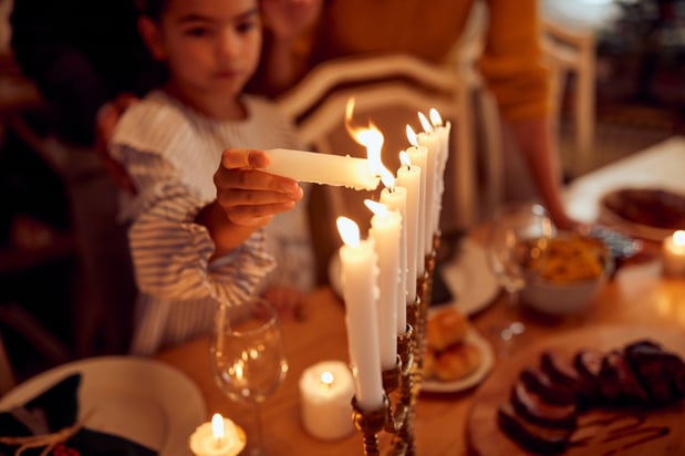 girl lighting menorah candles